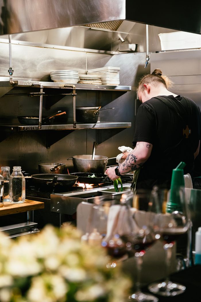 Chef preparing a meal in a professional kitchen with modern equipment.