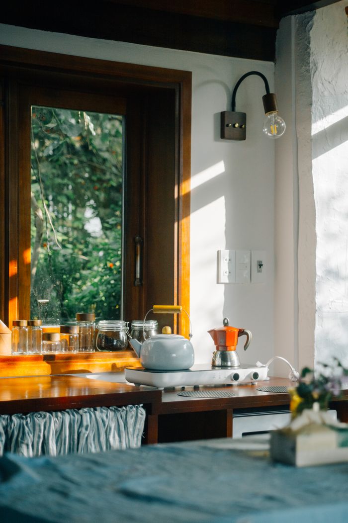 A serene kitchen corner with natural sunlight and a view of lush greenery outside.