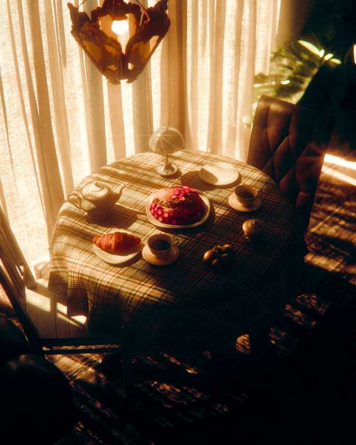 A sunlit breakfast table with pastries, a cake, and a warm ambiance.